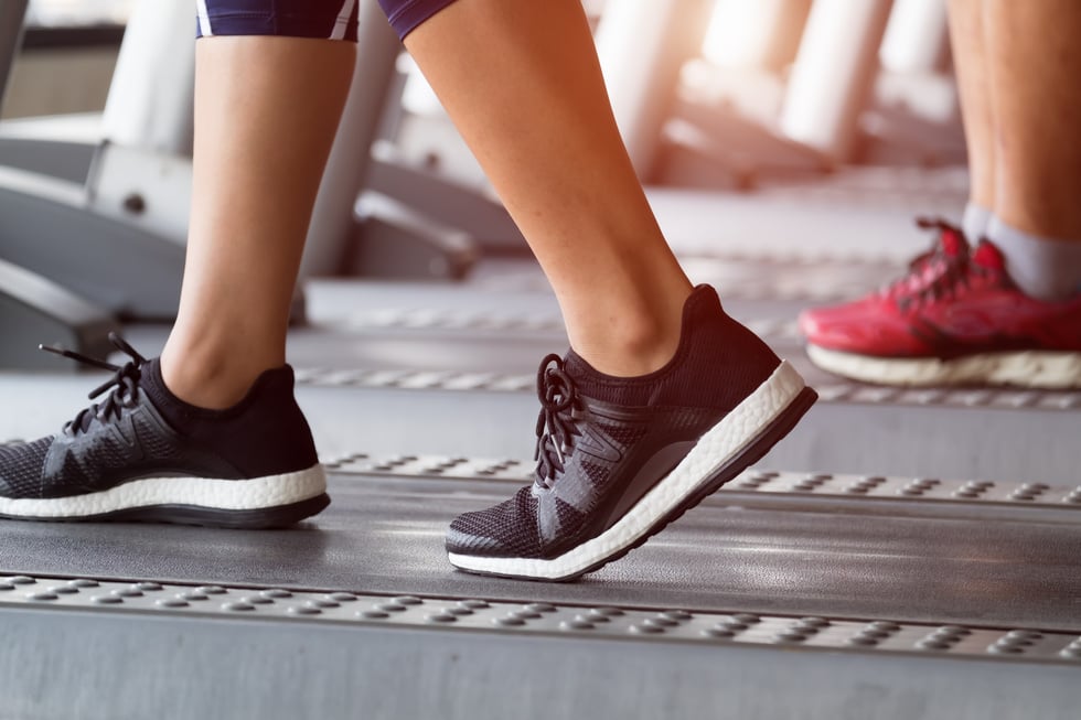 Female Feet on Treadmill at Fitness Gym